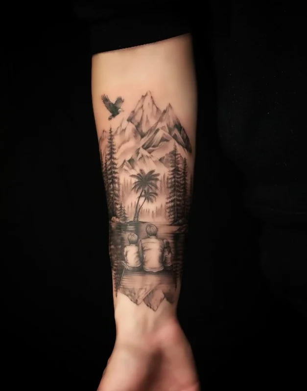 Black-and-grey mountain landscape tattoo on the inner forearm