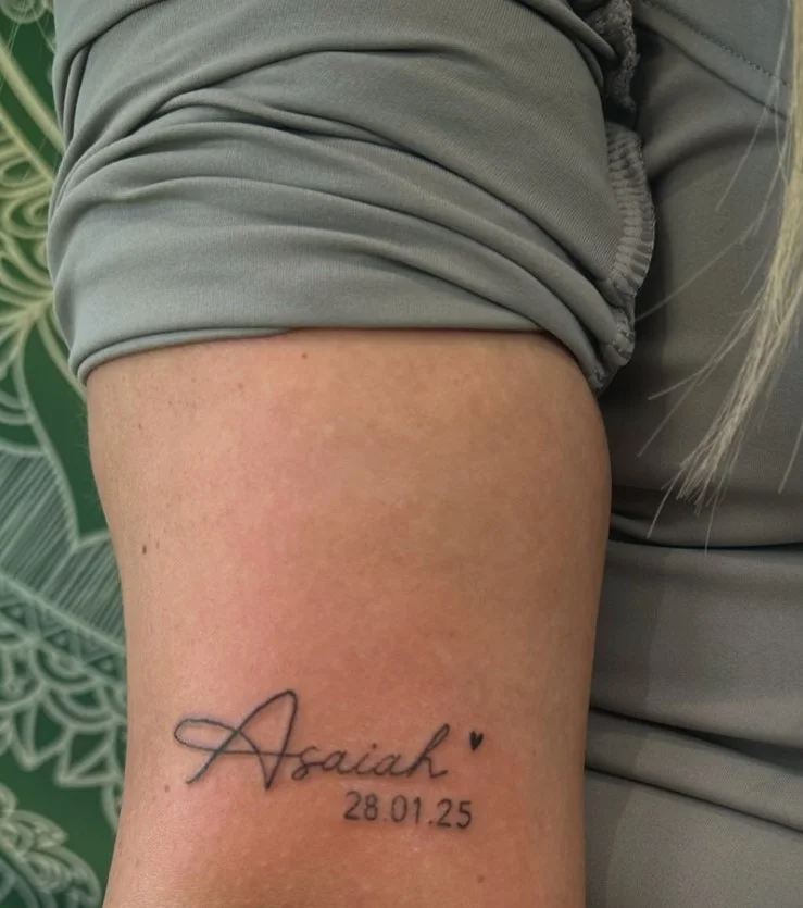 Personal name or date tattoo placed on the upper arm