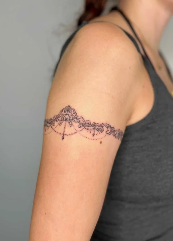 Ornamental bicep band tattoo with symmetrical decorative lines and patterns