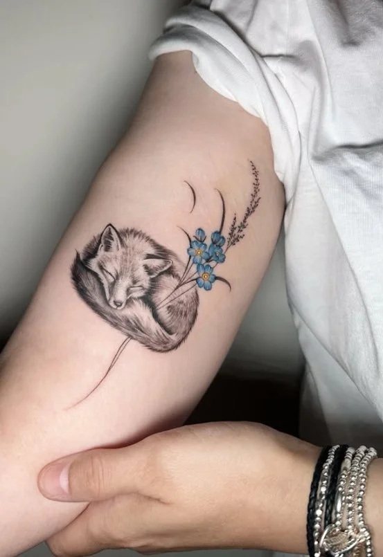 Small realistic fox tattoo in black and grey on the inner upper arm