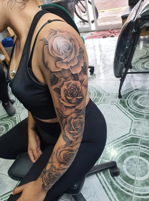 Rose upper arm tattoo idea for women with an elegant floral design