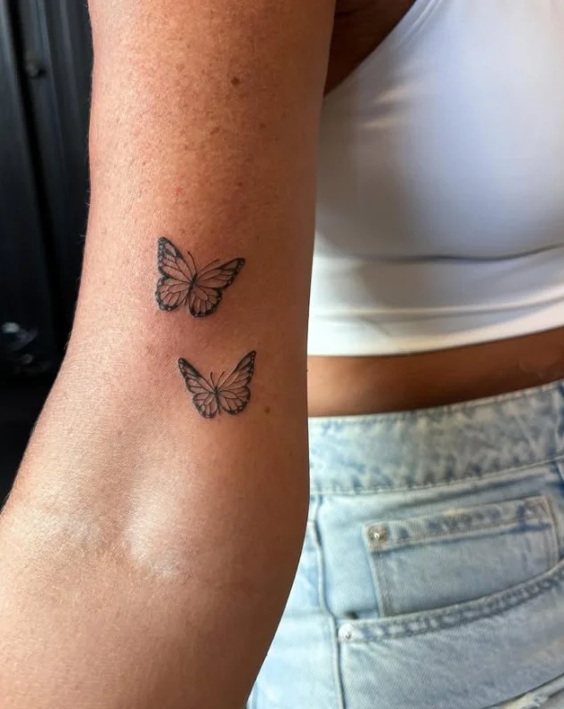 Small upper arm tattoo idea for women with a simple delicate design