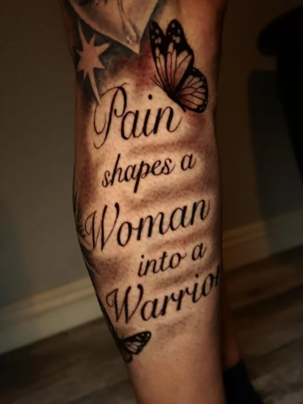 Vertical word or quote tattoo running along the calf