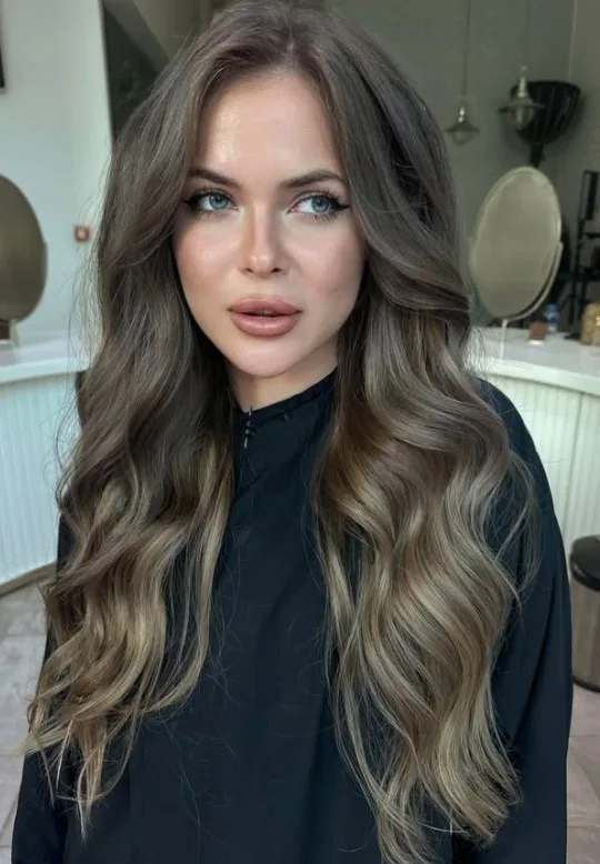 Ash blonde hair with cool, muted undertones and a smoky finish without strong golden tones.