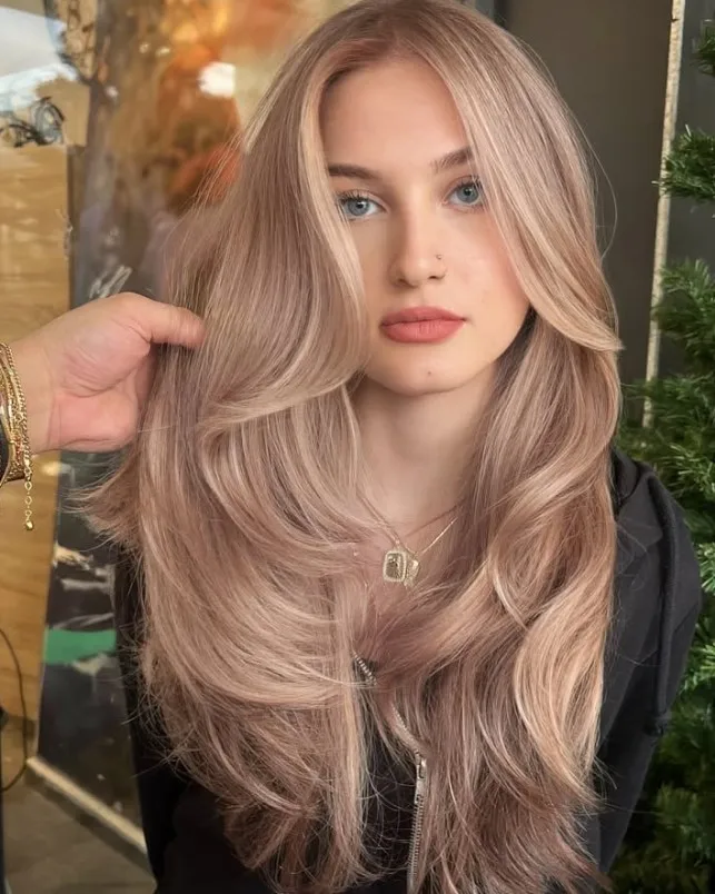 Beige blonde hair with soft sandy and neutral tones between golden blonde and ash blonde.