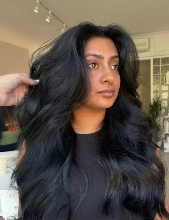 Woman with sleek blue-black hair showing subtle cool blue undertones and a glossy finish
