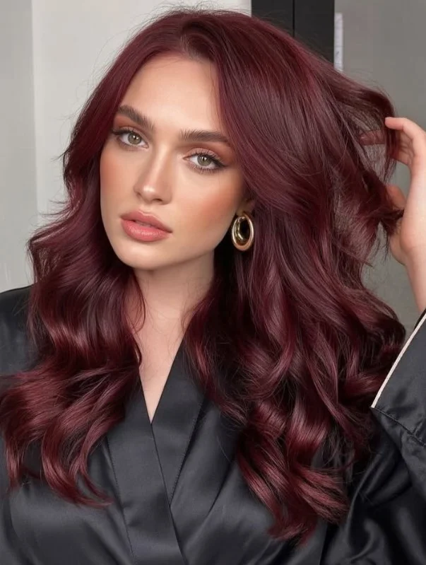 Woman with deep burgundy hair blending rich wine-red and berry undertones for a bold, jewel-toned hairstyle.