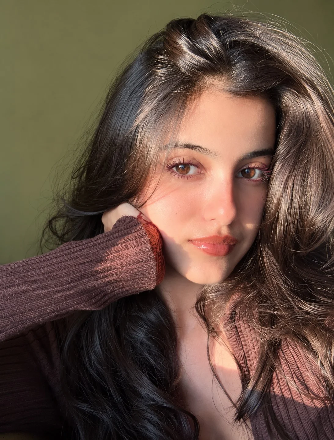 Woman with brown eyes wearing burgundy mascara for a warm wine-toned lash look
