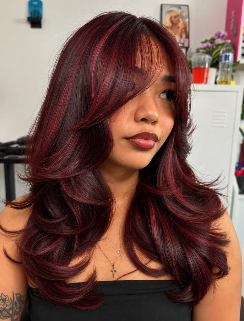 Visible burgundy ribbon highlights running through dark brown hair.