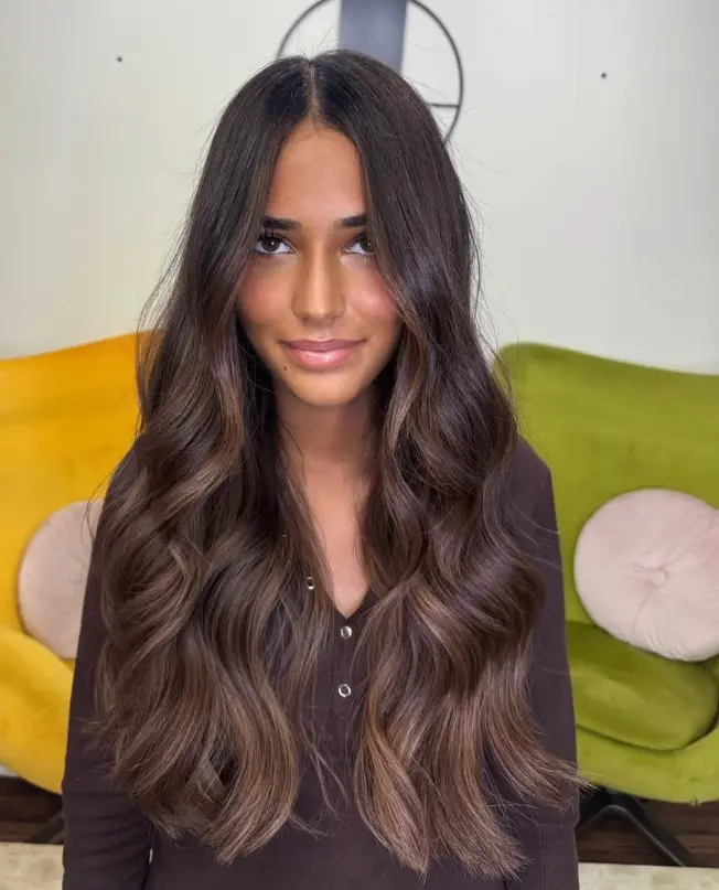Dark brown hair with blended caramel balayage highlights through the lengths.