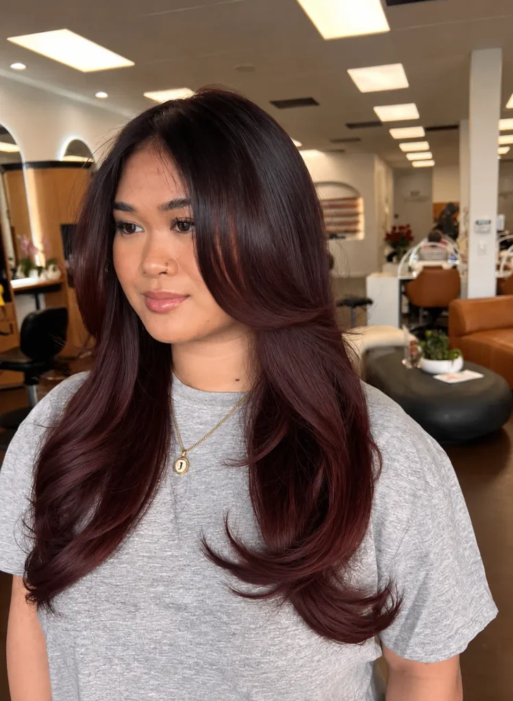 Cherry brown hair with a seamless blend from dark roots to cherry-colored lengths