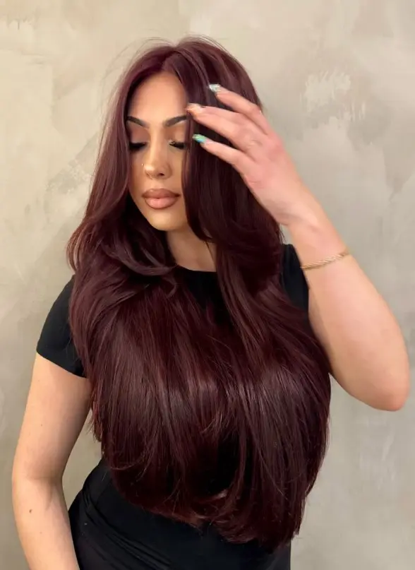 Dark cherry cola hair with a chocolate brown base and red undertones.