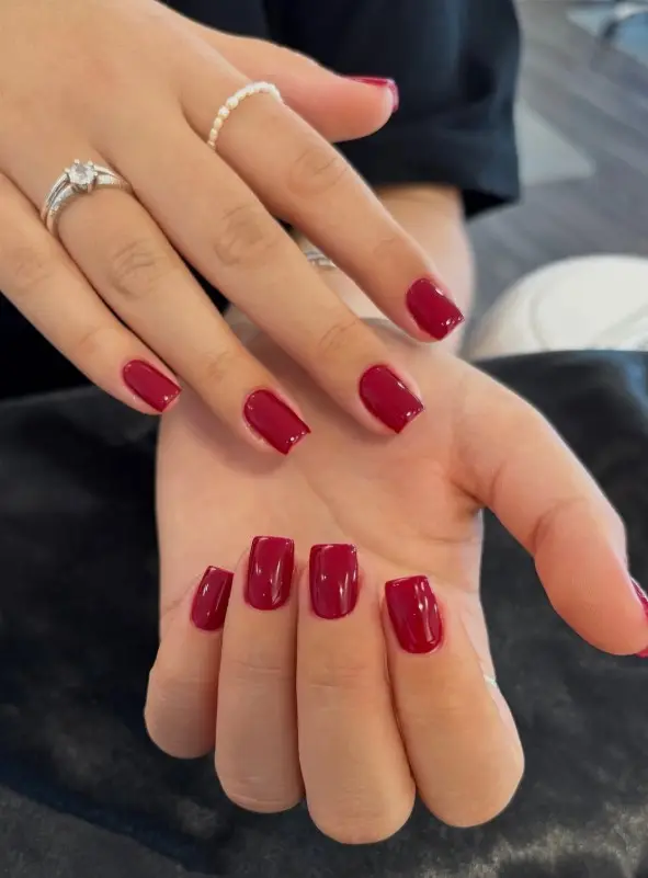 Short glossy cherry red Christmas nails with a smooth, shiny finish