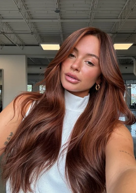 Woman with rich copper auburn hair showing warm red and copper tones against morena skin