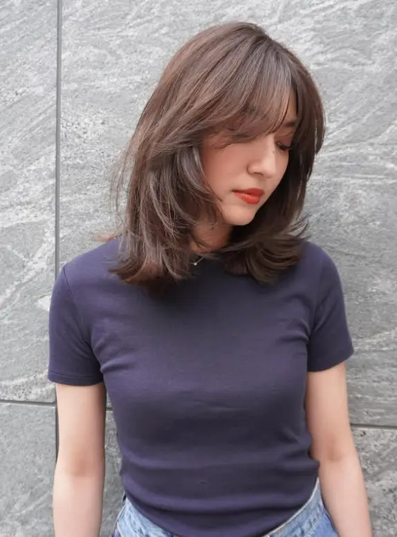 Dark brown shoulder-length butterfly lob with airy, feathered face-framing layers