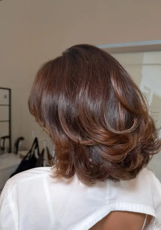 Dark brown shoulder-length hair with smooth retro flipped-out ends