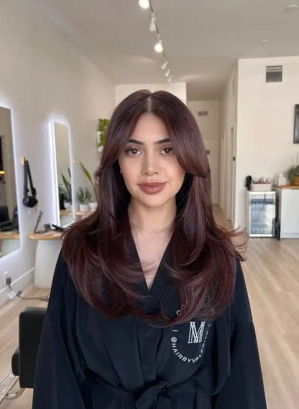 Dark cherry cola hair with a chocolate brown base and deep burgundy reflections
