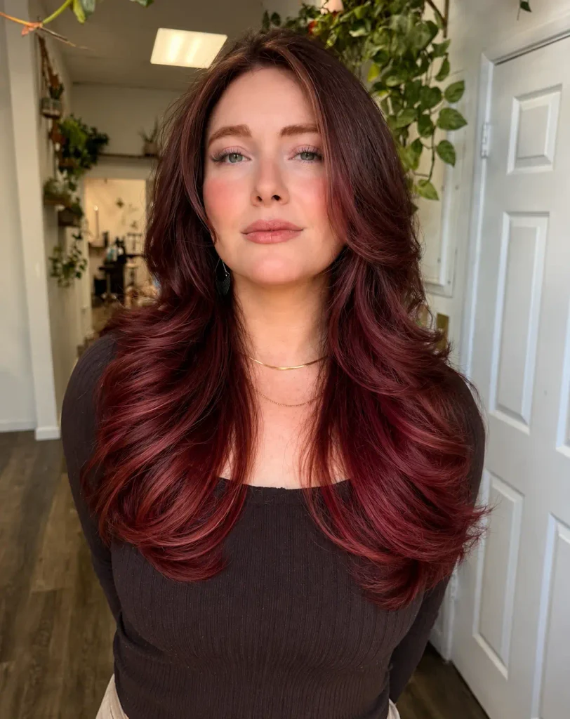 Dark brown roots gradually transitioning into cherry-red ombre ends.