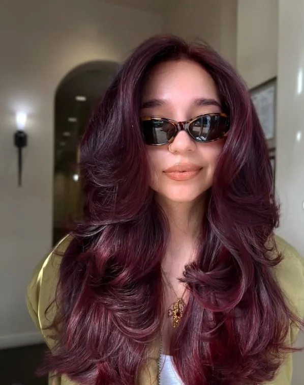 Deep burgundy hair color for light olive skin with rich wine-red and red-violet tones.