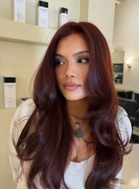 Woman with deep mahogany brown hair showing subtle red-violet tones throughout the brunette color