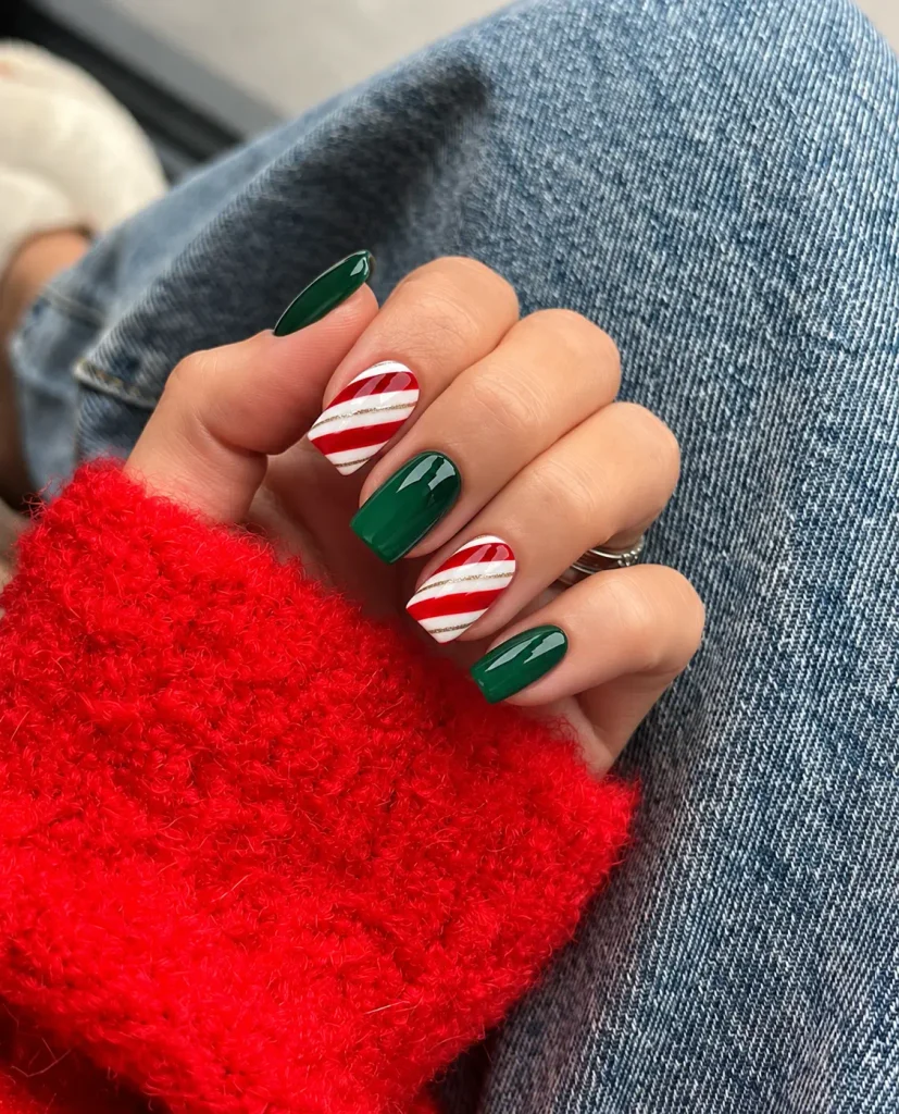 Emerald green Christmas nails paired with red and white candy cane striped accent nails