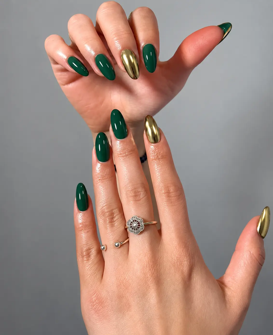 Glossy emerald green nails paired with mirror-finish gold accent nails for a reflective Christmas manicure