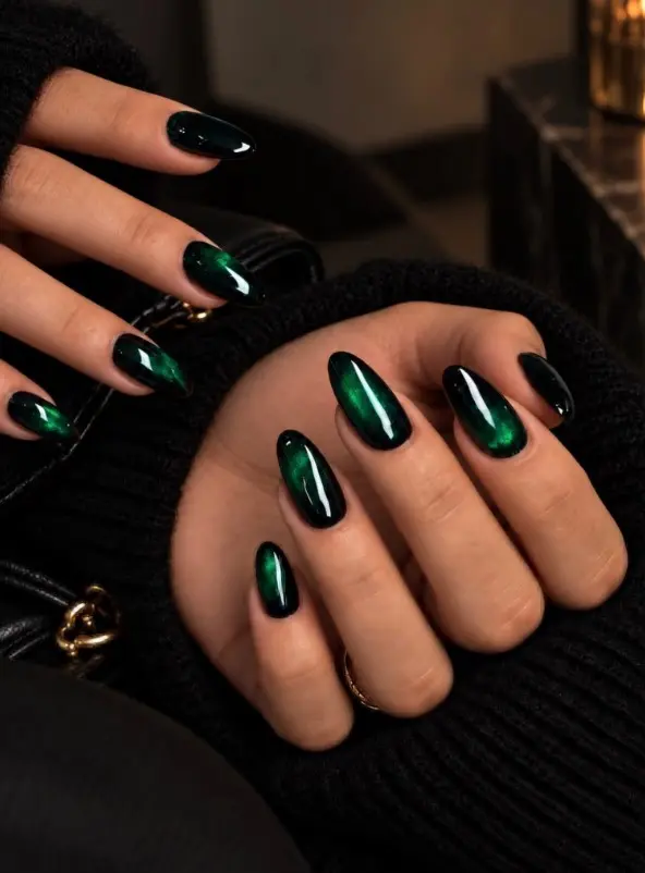 Emerald green velvet Christmas nails with magnetic cat-eye polish creating a soft, shifting shimmer on almond-shaped nails