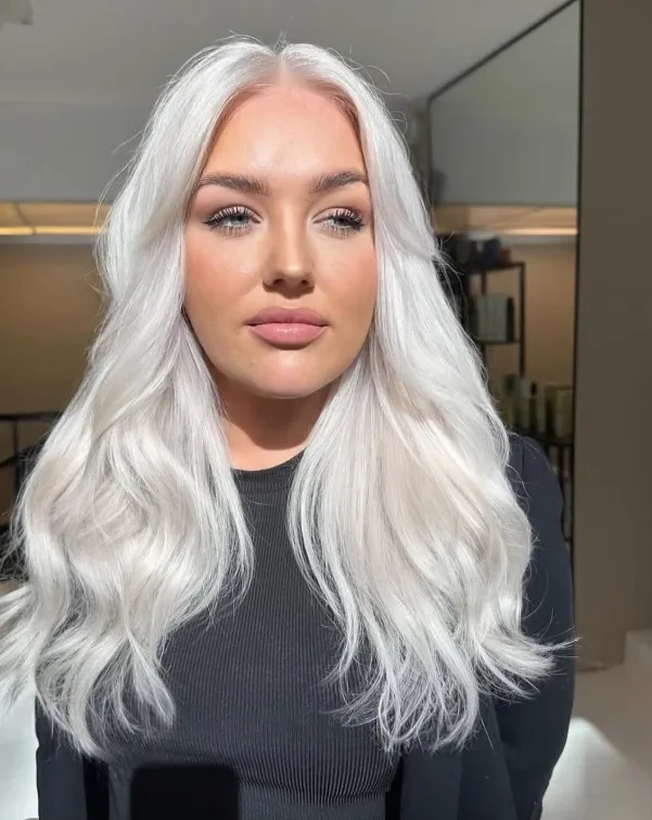 Very light icy platinum blonde hair with cool, nearly white tones, creating a bold contrast against pale skin.