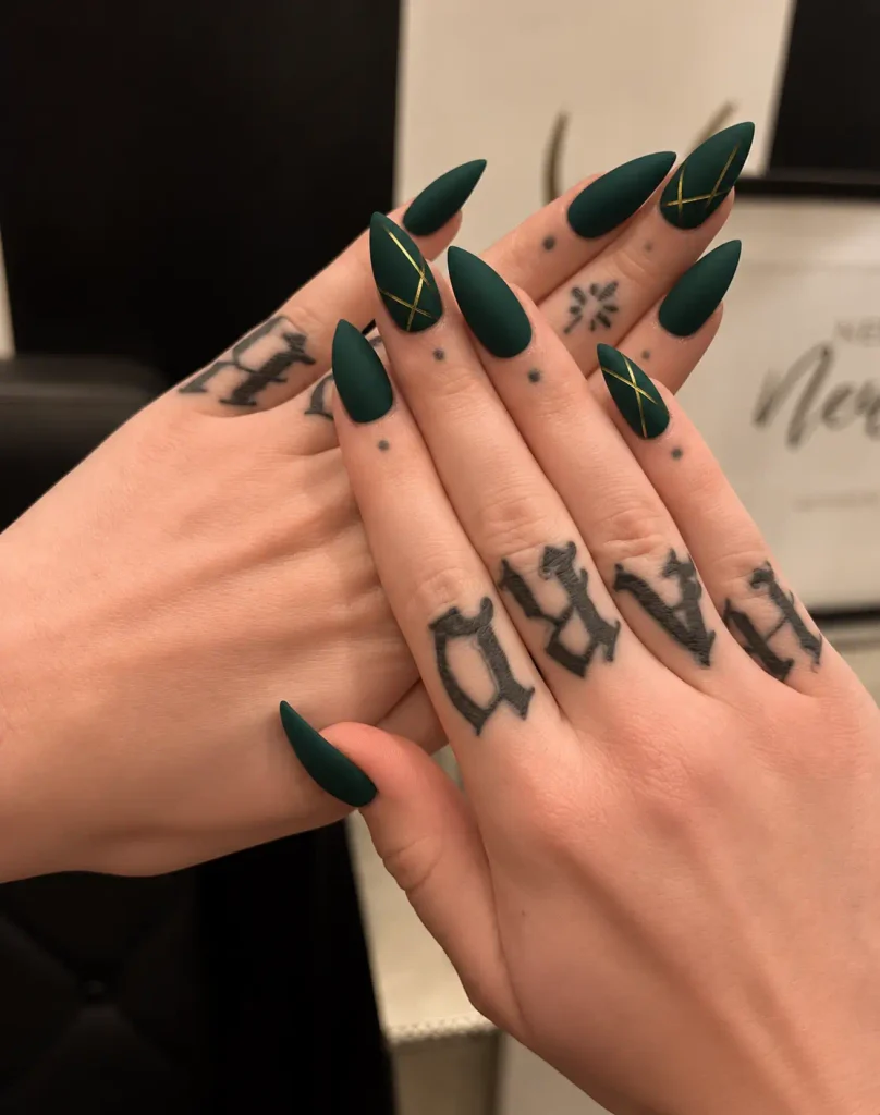 Matte forest green Christmas nails with thin gold geometric lines on selected accent nails