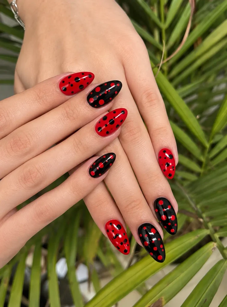Red and black polka dot nail art featuring a mix of small, medium, and large circles