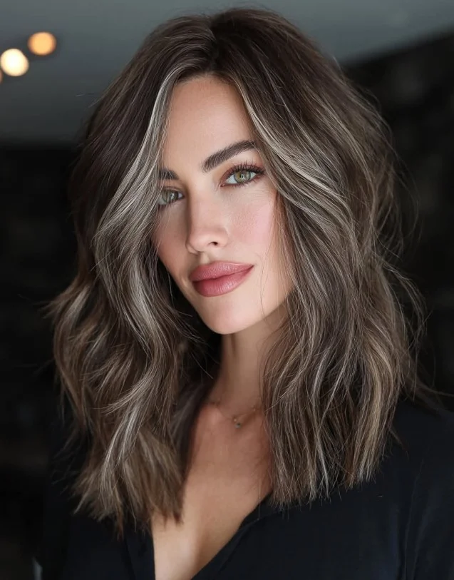Woman with cool mushroom brown hair featuring muted beige and ash undertones for a soft, modern brunette look.