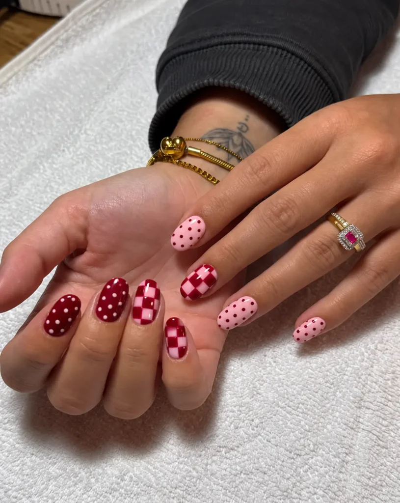 Pink and red checkerboard nail art paired with polka-dot accent nails.