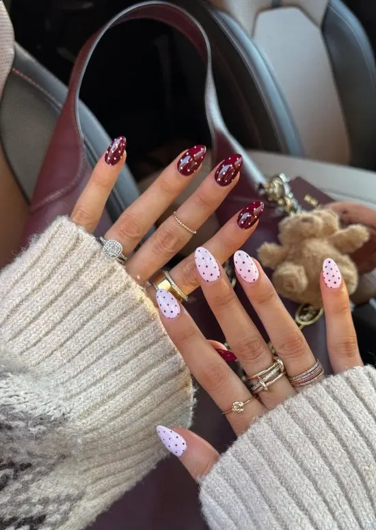 Alternating pink and red nails with contrasting polka-dot patterns.