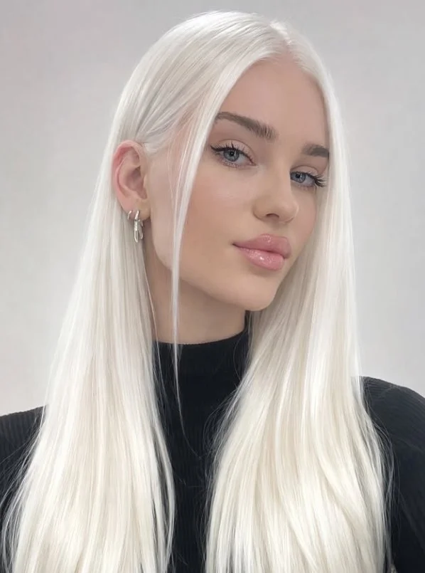 Woman with very light platinum blonde hair featuring cool, icy tones for a bold, high-contrast hairstyle against pale skin.