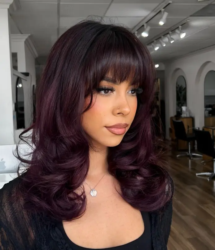 Dark plum brunette hair with subtle purple undertones.