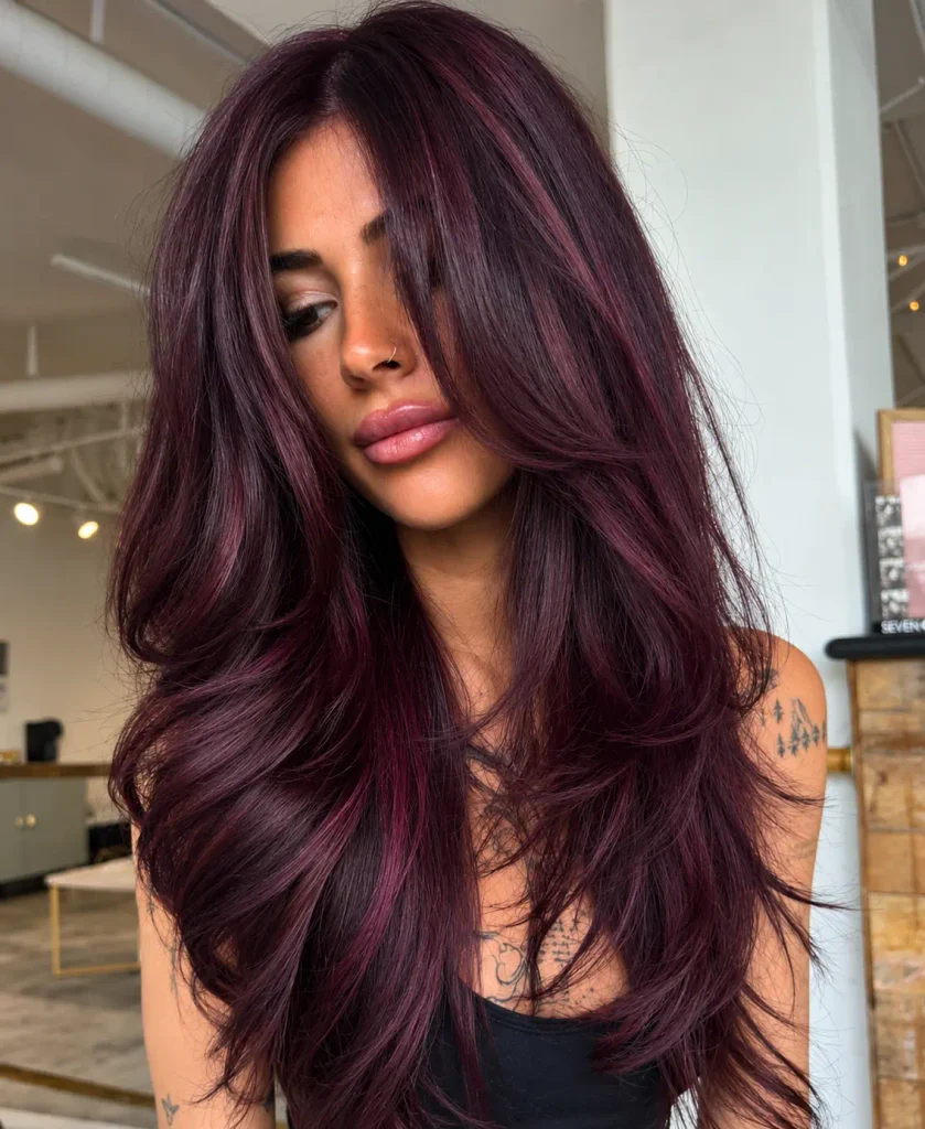 Deep plum highlights adding violet tones to dark brunette hair