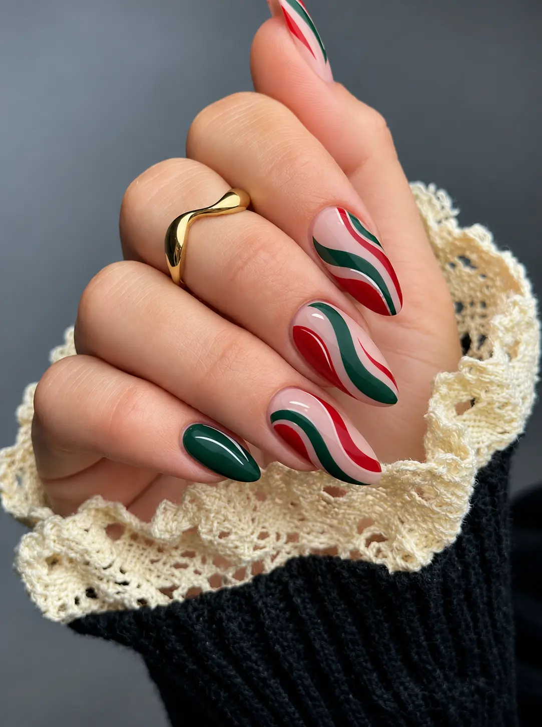 Red and green abstract Christmas swirl nails with curved lines over a sheer nude base