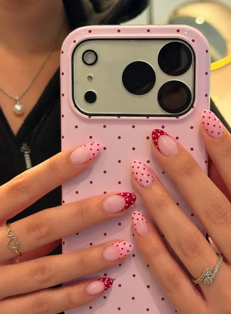 Retro bubblegum-pink nails with large, evenly spaced cherry-red polka dots.