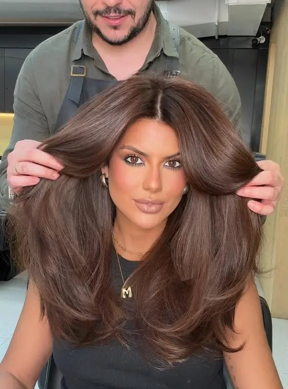  Long chocolate brown hair with a glossy finish on light brown skin.