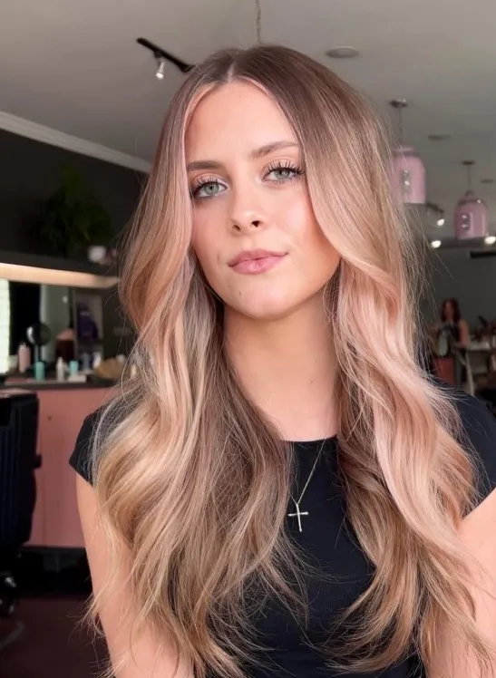 Rose gold hair blending delicate pink, peach, and golden tones for a soft, distinctive finish.