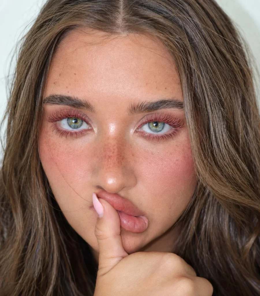 Woman with blue eyes wearing rose pink mascara for a soft feminine lash look