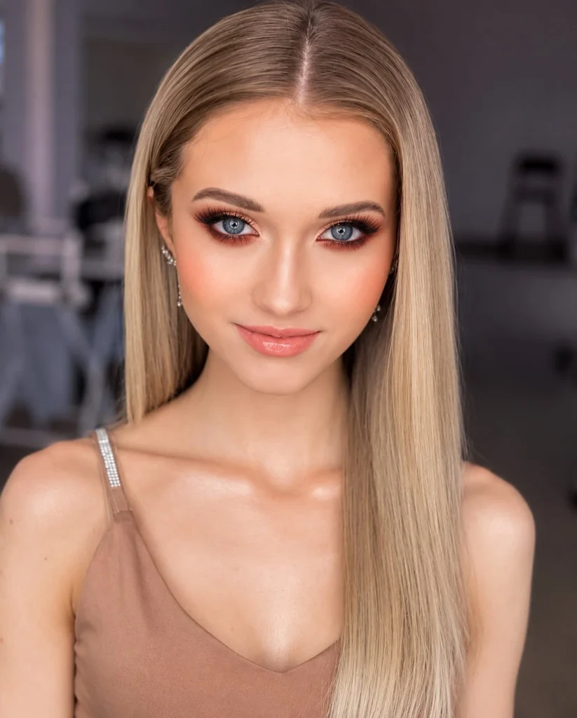 Blue eyes with rich rust eyeshadow smudged along the upper and lower lash lines and warm bronze across the lids.