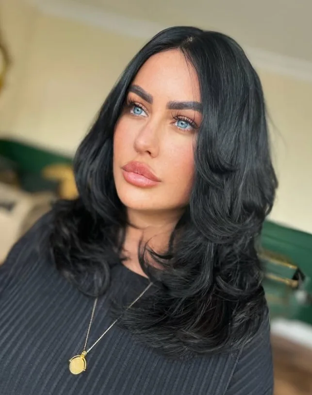 Long soft black hair with a deep, natural-looking finish that contrasts with pale skin.
