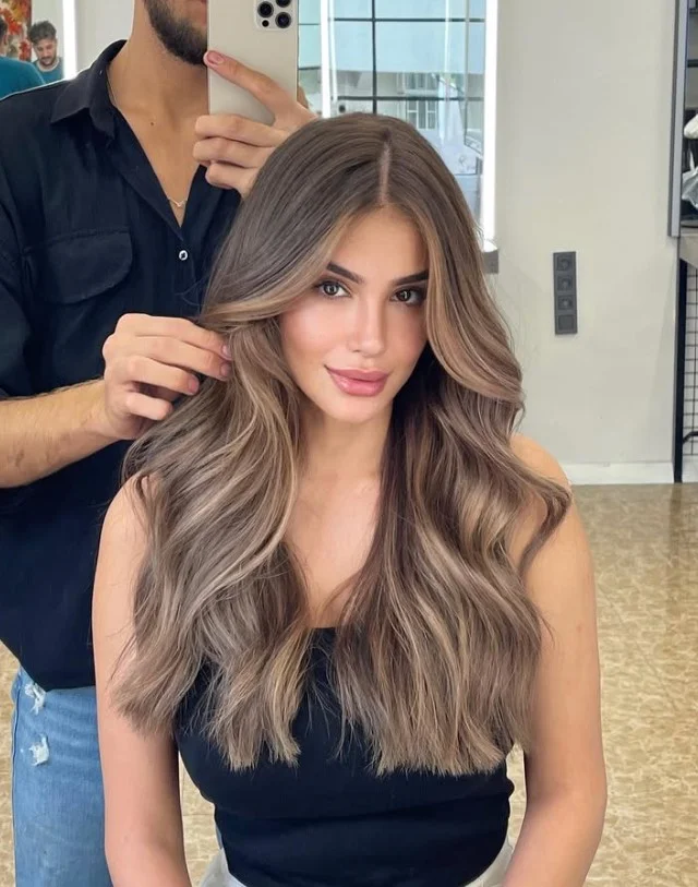 Soft bronde hair color for light olive skin, blending brown and blonde tones for a natural dimensional finish.
