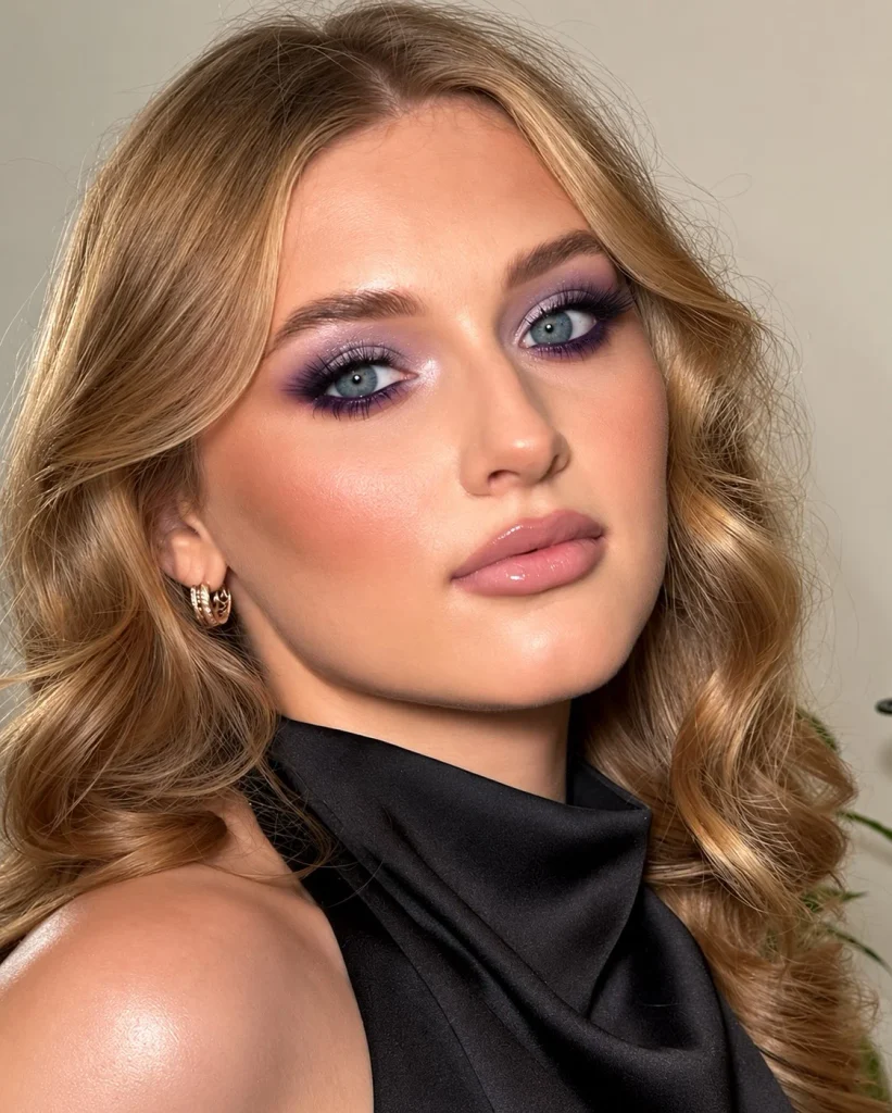 Blue eyes with soft lilac eyeshadow across the lids and deeper purple definition along the upper lash line.