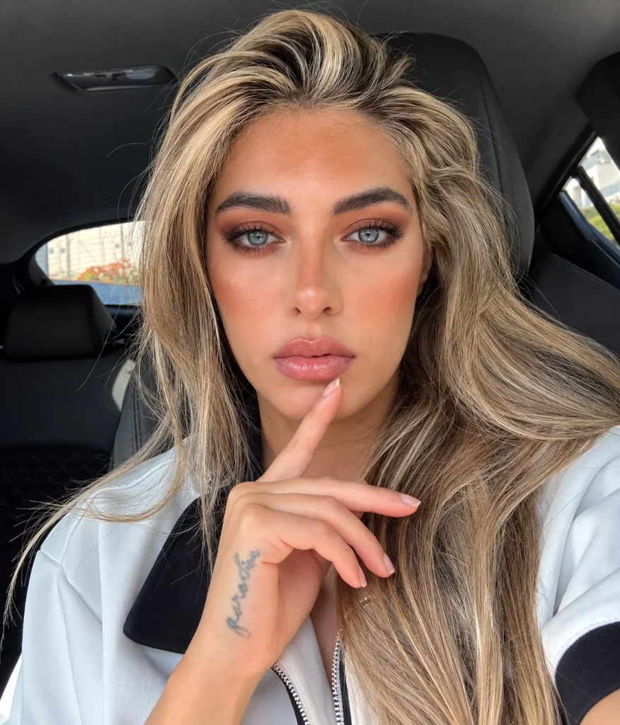 Blue eyes with warm terracotta eyeshadow across the lids and deep brown blended into the outer corners for a soft smoky effect.