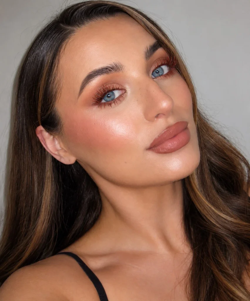 Woman with blue eyes wearing terracotta mascara for a warm earthy makeup look