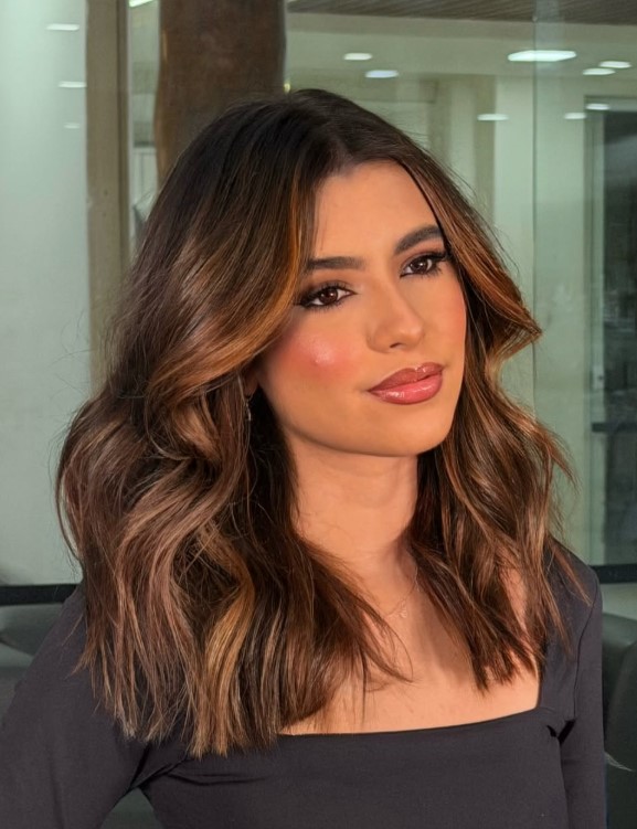 Toffee highlights transitioning from dark brown roots to lighter lengths